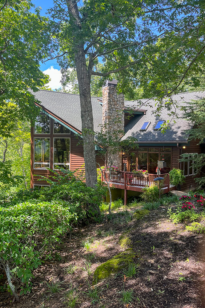 Custom mountain cabin surrounded by mature trees in a wooded Smoky Mountain setting