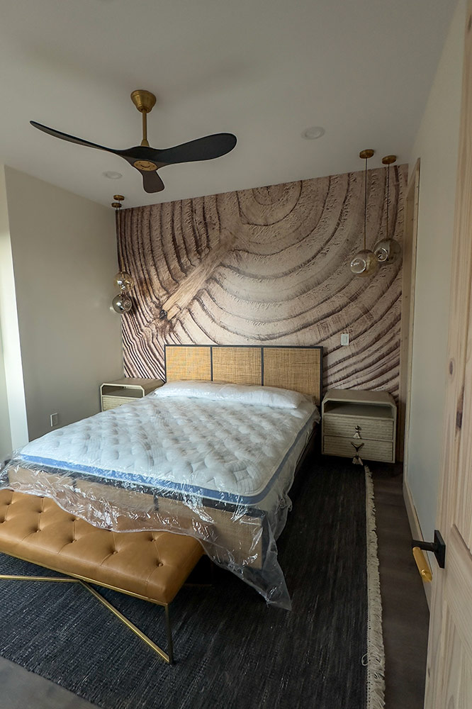 Cabin bedroom with custom wood accent wall and ceiling fan
