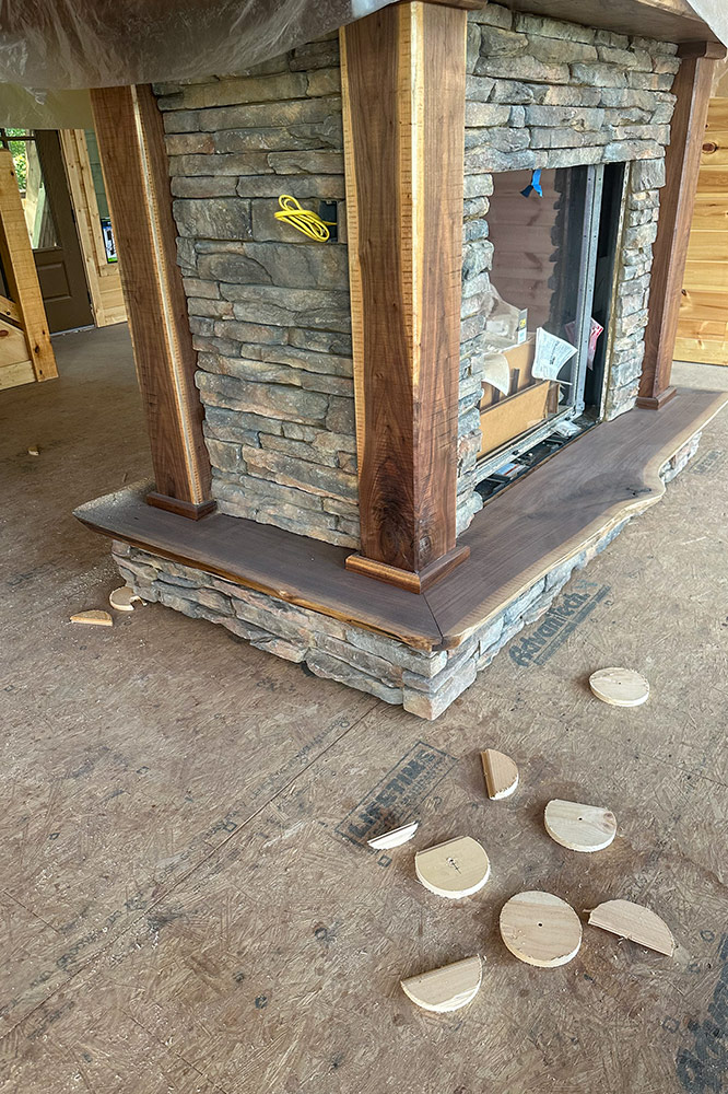 Custom stone fireplace with natural wood mantel and live-edge hearth