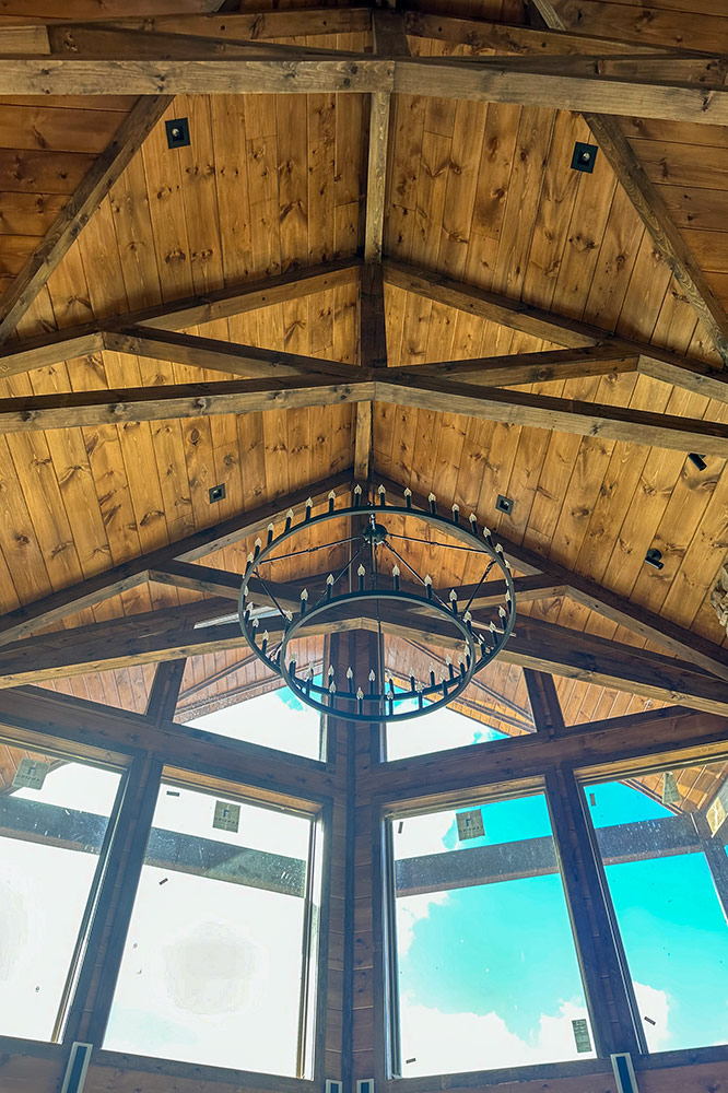 Vaulted wood ceiling with exposed timber trusses and large custom windows