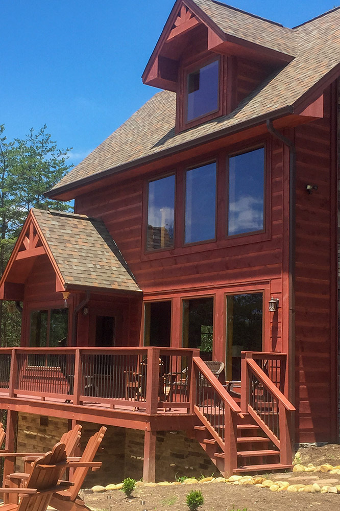 Multi-level custom log cabin with covered decks and rustic wood exterior
