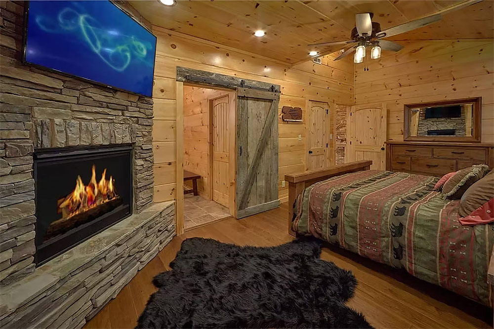 Bedroom with fireplace, wood walls, and luxury finishes