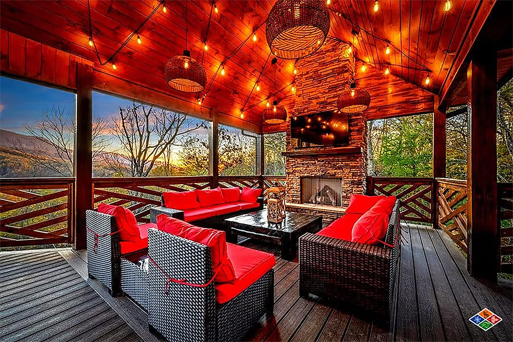 Covered outdoor lounge with fireplace and mountain views