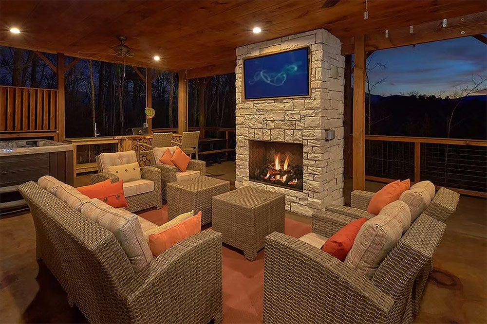 Covered patio with stone fireplace and comfortable seating