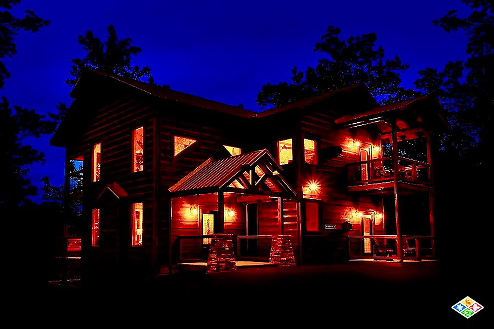 Luxury custom cabin illuminated at night in the Smoky Mountains